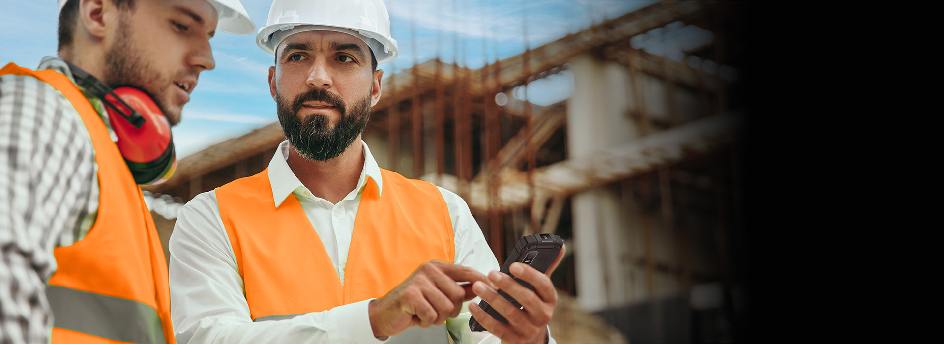 HAMMER HORIZON LTE  kierownik budowy rozmawia z pracownikiem,  pokazuje telefon