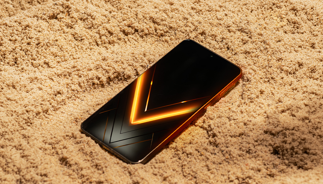 Smartfon HAMMER VENTUS 5G na piasku z pomarańczowym motywem V na ekranie