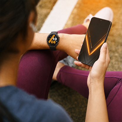 Osoba trzymająca smartfon HAMMER VENTUS 5G i nosząca smartwatch HAMMER WATCH VENTUS PRO
