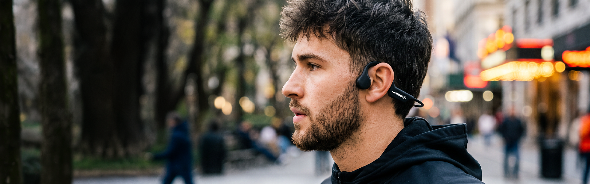 Czarne słuchawki kostne HAMMER BONE HEADPHONES założone na mężczyźnie w miejskim otoczeniu
