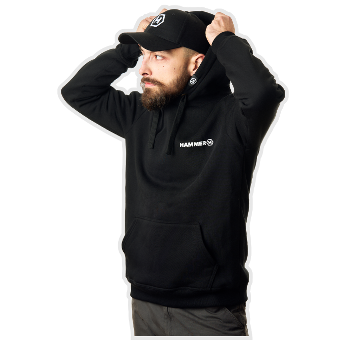 The man puts on a hoodie and is wearing a HAMMER WEAR sweatshirt and cap