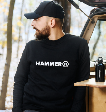 Man standing next to a car, wearing HAMMER WEAR
