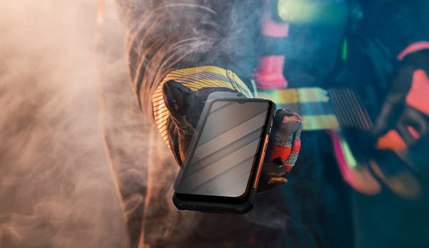 Strażak podaje smartfon HAMMER CONSTRUCTION 2 THERMAL 5G wokół dym