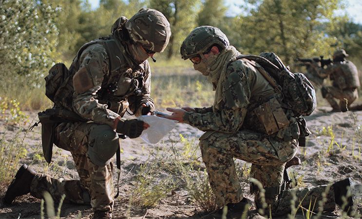 HAMMER standrard militarny żołnierze obmyślają strategię na polu walki.