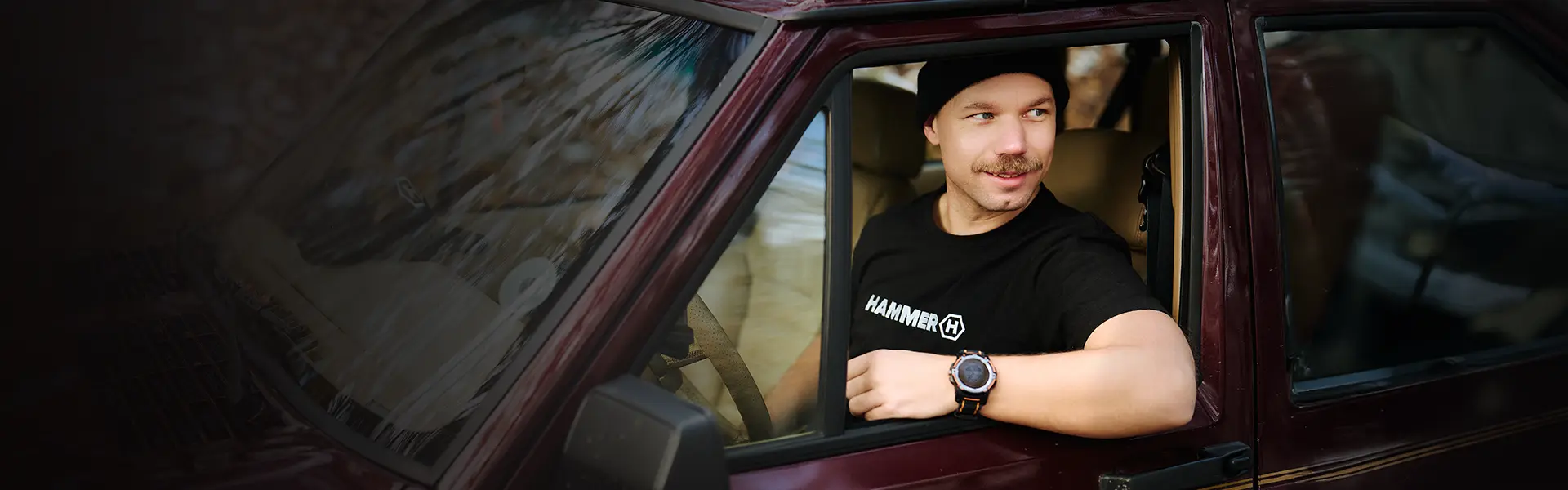 HAMMER T-shirt mężczyzna jedzie autem na wycieczkę do lasu.